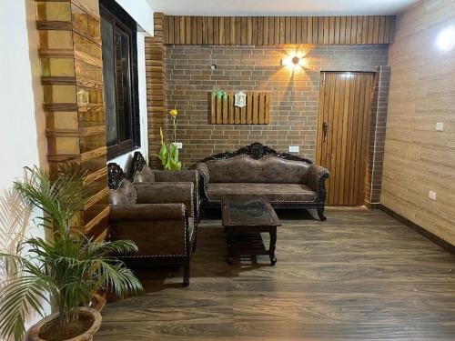 a living room with two chairs and a couch at Fancy and Modern Apartment in Patna