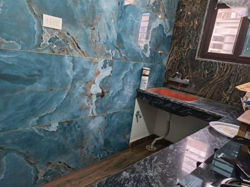 a bathroom with a blue marble wall with a sink at Fancy and Modern Apartment in Patna