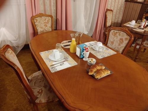 a wooden table with a plate of food on it at Nogapatio - Maison d'Hôtes - BnB in Nogaro