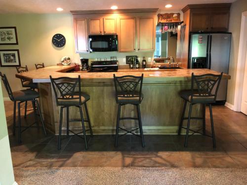 a kitchen with a bar with four stools at Luxury on the lake in Indianapolis