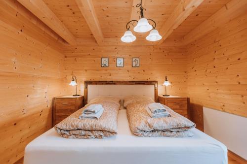 ein Schlafzimmer mit einem Bett in einem Holzzimmer in der Unterkunft Chalet Aconitum in Murau