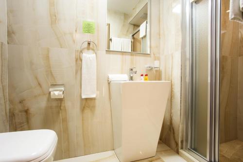 a bathroom with a toilet and a glass shower at Sofia Place Hotel by HMG in Sofia