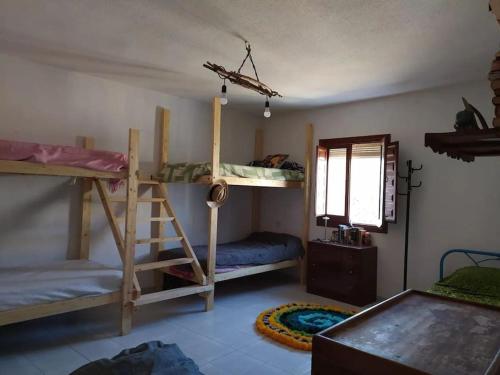 a room with two bunk beds and a window at La Casa del Río, piscina natural a 5 min en coche in Villacarrillo