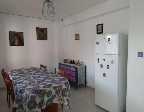a dining room with a table and a white refrigerator at La Casa del Río, piscina natural a 5 min en coche in Villacarrillo