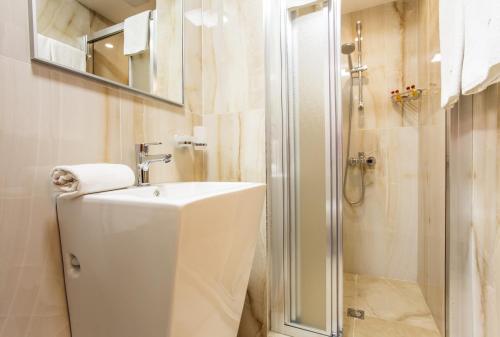 a bathroom with a shower and a toilet and a sink at Sofia Place Hotel by HMG in Sofia