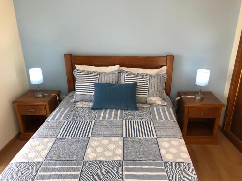 a bedroom with a bed with pillows and two lamps at Casa da Forja in Aldeia das Dez