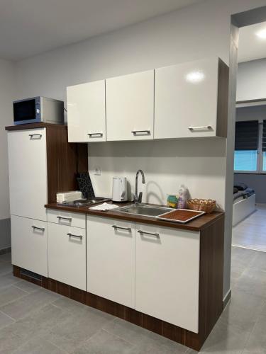 a kitchen with white cabinets and a sink at Apartmani "Stari Grad - Samobor" in Samobor