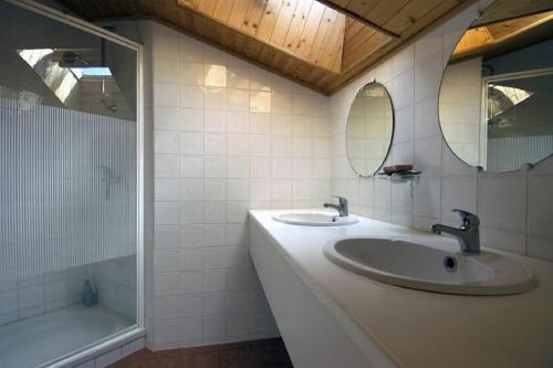 une salle de bain avec deux lavabos, une baignoire et un miroir dans l'établissement Villa Champie, à Pradons
