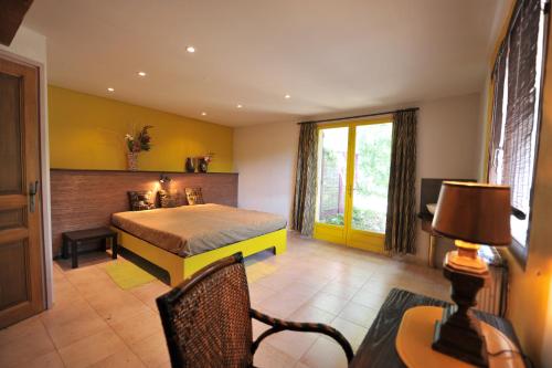 ein Schlafzimmer mit einem Bett und einem Schreibtisch sowie einem Tisch mit einem Stuhl in der Unterkunft Villa Champie in Pradons