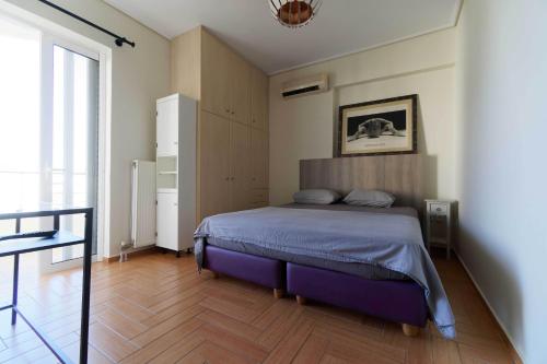 Cozy & Relaxing Apartments-Agia Paraskevi في أثينا: غرفة نوم بسرير وارضية خشبية