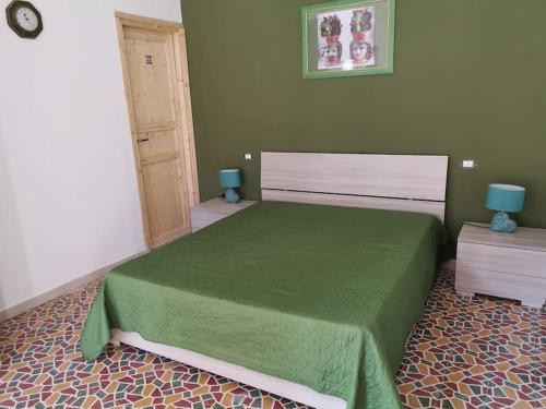 - une chambre avec un lit doté d'un couvre-lit vert dans l'établissement NA ZA ROSA, à Porto Empedocle