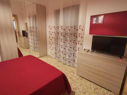 a bedroom with a bed and a flat screen tv at NA ZA ROSA in Porto Empedocle