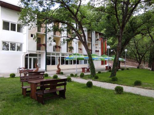 un edificio con bancos y sombrillas en un parque en BANJA SVETA NEDELA, en Katlanovo