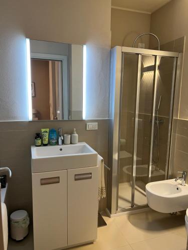 a bathroom with a shower and a sink and a mirror at Bogogno Golf private luxury apartment in Bogogno