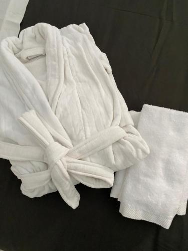 uma toalha branca sentada em cima de uma cama em Suite23_Ortigia em Siracusa