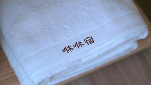 a white towel with writing on it sitting on a table at 咻咻宿 Xiuxiu 電梯宅 in Taitung City