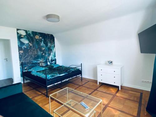 Cette chambre comprend un lit et une table en verre. dans l'établissement Dümmer Perle Apartments, à Hüde