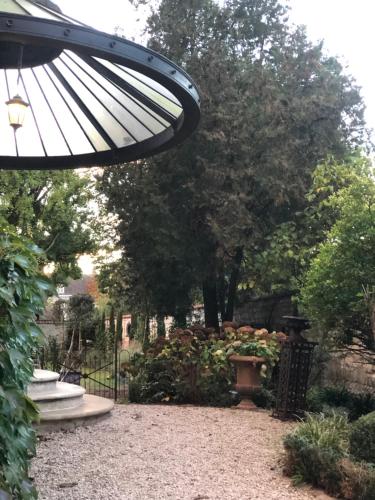 Elle offre une vue sur un jardin avec un parasol. dans l'établissement DUPLEX AVENUE ROYALE, à Compiègne