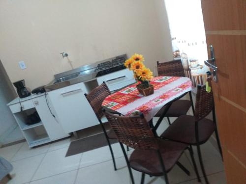 a kitchen with a table and chairs with flowers on it at Dom Gabriel 4 in Campos dos Goytacazes