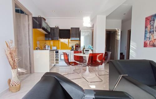 a living room with a table and red chairs at Sea La Vie Apt. in Paleokastritsa
