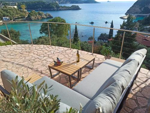 a couch on a patio with a view of the ocean at Sea La Vie Apt. in Paleokastritsa