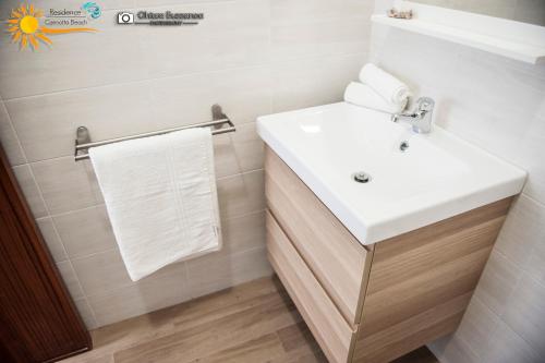 ein Badezimmer mit einem weißen Waschbecken und einem weißen Handtuch in der Unterkunft Cannotta Beach - Salina in Terme Vigliatore