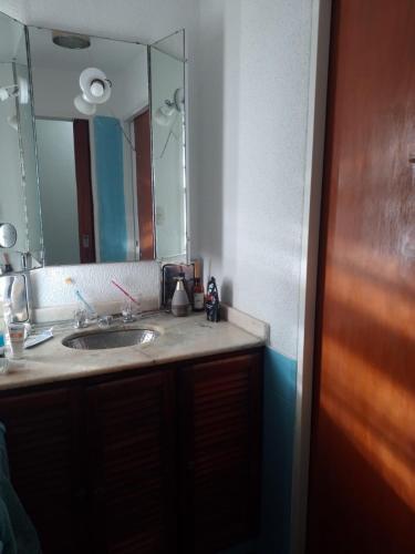 baño con lavabo y espejo grande en Casa Alvear en Marcos Juárez