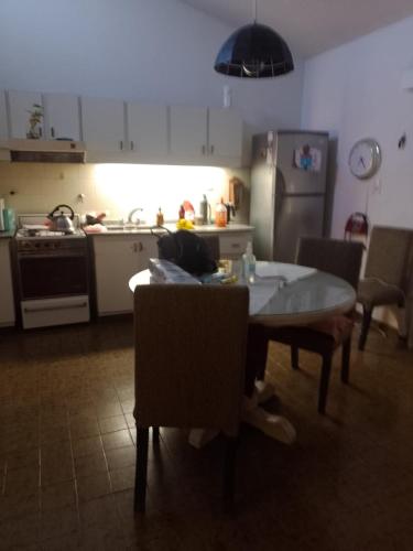 cocina con mesa y sillas y cocina con nevera en Casa Alvear en Marcos Juárez