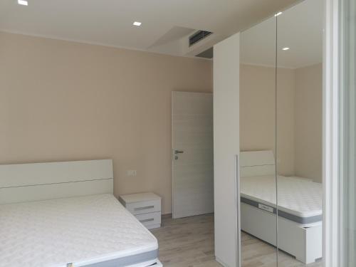 - une chambre avec 2 lits et un miroir dans l'établissement APPARTAMENTI SOLE-LUNA, à Francavilla al Mare