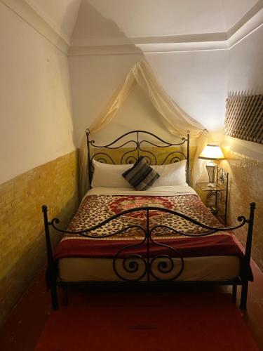 1 dormitorio con 1 cama con dosel en Riad Dar Lilas, en Marrakech