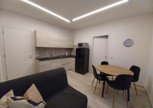 a living room with a couch and a table and a kitchen at Casa DelFalco in Domodossola