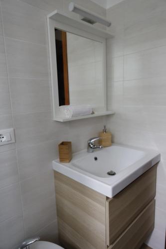 a bathroom with a sink and a mirror and a toilet at Cannotta Beach - Alicudi in Terme Vigliatore