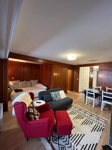 a bedroom with a bed and a couch and chairs at Renovated Apartment 5 min to Crans Montana Center in Crans-Montana
