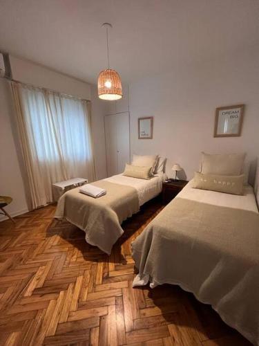 1 dormitorio con 2 camas y luz colgante en departamento moderno en Belgrano en Buenos Aires