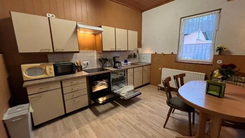 a kitchen with a table and a microwave and a stove at Monteure, ganzes Haus, Schwarzheide, Haus 1 in Schwarzheide