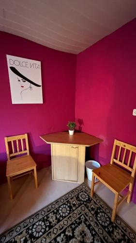 a room with two chairs and a table and a pink wall at Monteure, ganzes Haus, Schwarzheide, Haus 1 in Schwarzheide