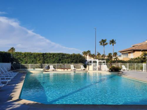 - une piscine avec des chaises longues dans la cour dans l'établissement Cap HERMES Vue PORT Studio 30m2 Climatise Piscine, à Fréjus