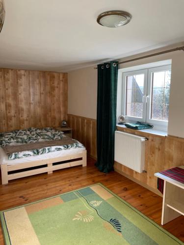 sypialnia z łóżkiem, oknem i dywanem w obiekcie Willa Toskania w mieście Lądek-Zdrój