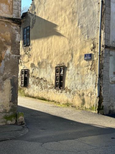 an old building with a shadow on the side of it at Apartmani "Stari Grad - Samobor" in Samobor