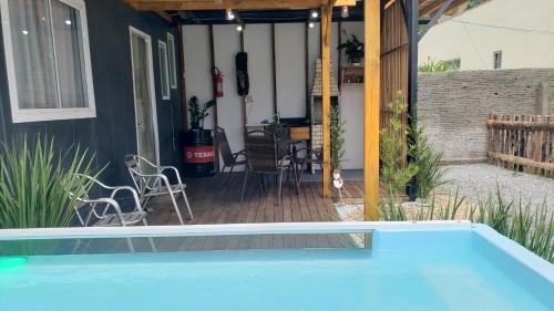 a swimming pool in front of a house with a patio at Apart-Container Penha in Navegantes