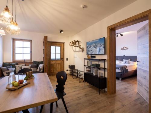 a living room with a dining room table and a bedroom at Alpenliebe Zillertal in Hart im Zillertal
