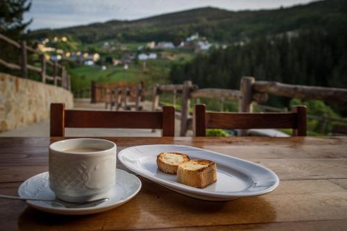 a plate of bread and a cup of coffee on a table at Apartamentos El Sualleiro in Santa Eulalia de Oscos