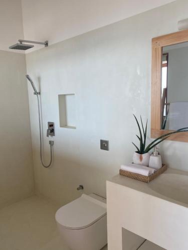 a white bathroom with a toilet and a sink at Lihinya Beach Villa Ahangama in Ahangama