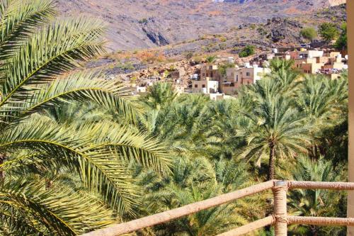 um grupo de palmeiras e edifícios numa cidade em Balad Sayt Heritage Inn em Bilād Sayt