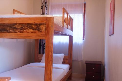 a bedroom with two bunk beds and a window at SILVER OAKS HOTEL Boma in Fort Portal