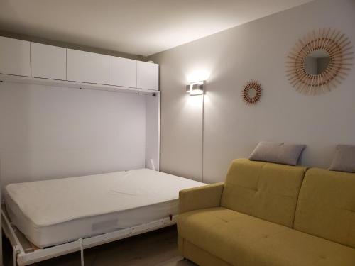 a room with a bed and a couch and a mirror at MIOUGRANO Studio 25m2 Piscine 300m Plage in Fréjus