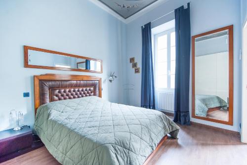 a bedroom with a large bed and a mirror at Merveilleux 2P, à 50 m de la plage, en plein centre ville in Menton