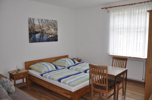 a bedroom with a bed with a table and chairs at Ferienhaus Nordstrand Whg 2 in Baltrum