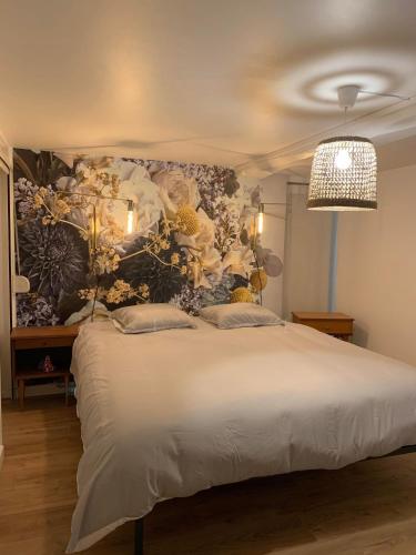 - une chambre avec un grand lit et un mur fleuri dans l'établissement Duplex Vieux Lille, à Lille