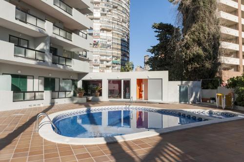 a swimming pool in the courtyard of a building at Apartamentos Michel Angelo Benidorm in Benidorm